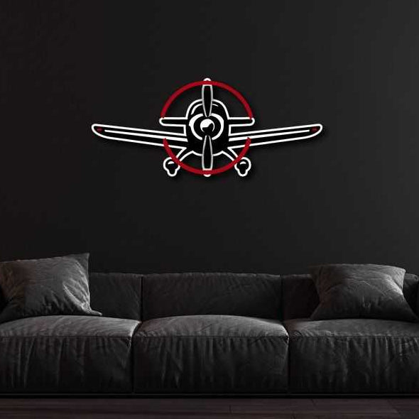 Multicolor metal sign featuring a propeller plane design mounted on a black wall above a dark gray sofa.