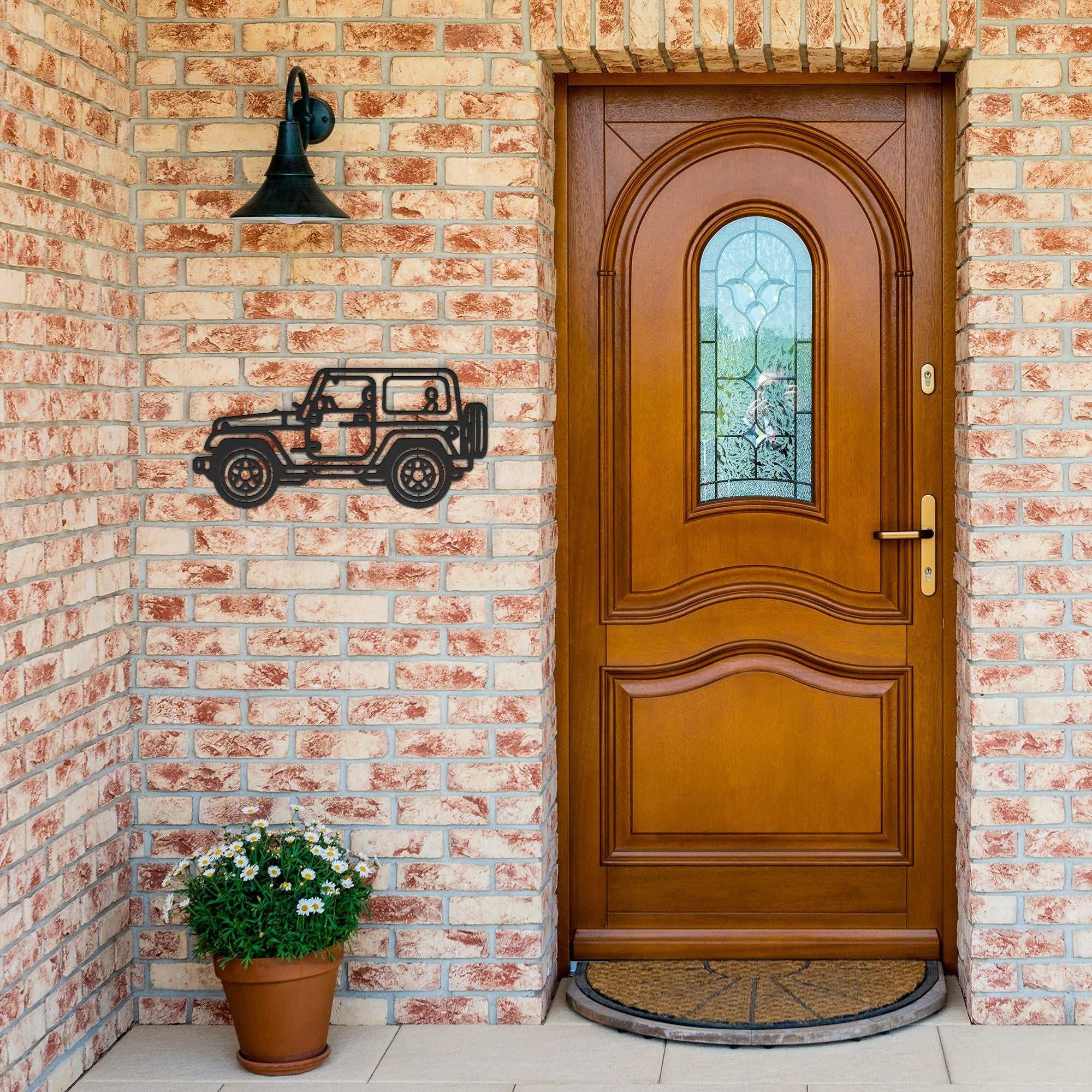 4x4 off road metal wall art in black powder-coated steel mounted on brick wall beside wooden door
