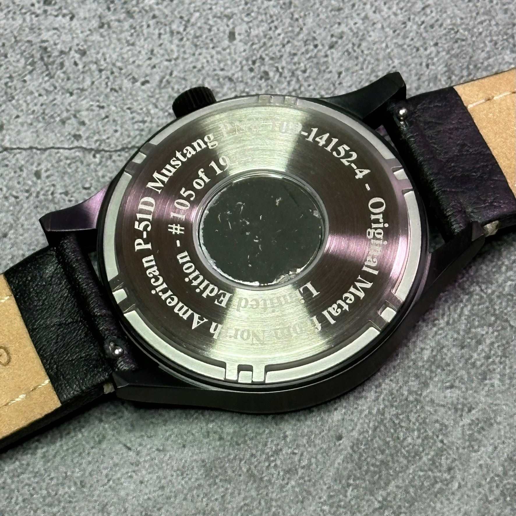Back view of P-51 Mustang tribute watch with black leather band and stainless steel case showing limited edition engraving