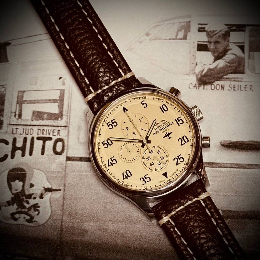 B-25 Mitchell tribute watch with polished stainless steel case, beige dial, and brown leather band with stitching