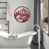 Bear camping metal wall art in a modern bathroom, featuring a bear, mountains, and tent design in red.