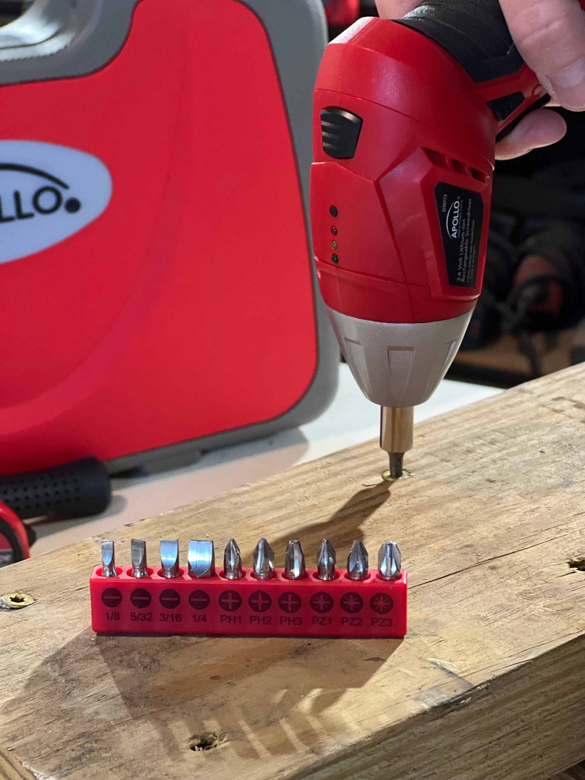 135 piece household tool set with cordless lithium-ion screwdriver and multiple screwdriver bits on wooden surface