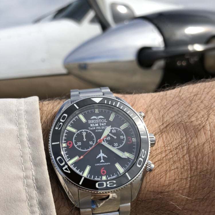747 Tribute watch with stainless steel case, black dial, and KLM 747 airframe artifact