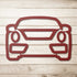 Red metal wall art shaped like a car front on wooden background
