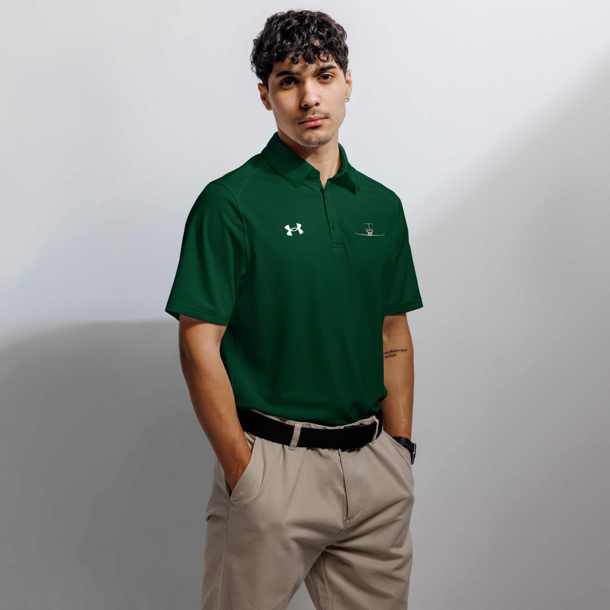 Man wearing green performance fit pilot polo shirt with embroidered private jet logo and Under Armour logo on chest