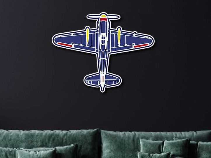 Multicolor aviation metal wall art in classic plane design mounted on dark wall above green sofa
