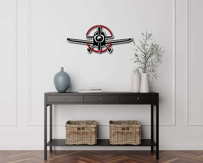 Multicolor metal sign shaped like a propeller plane hanging on a white wall above a black console table with decorative vases and wicker baskets.