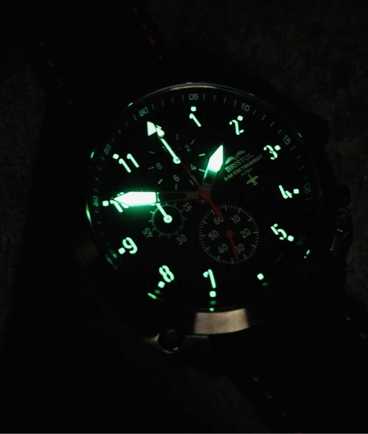 A-10 Thunderbolt watch with glowing Super Luminova dial and black leather band in low light
