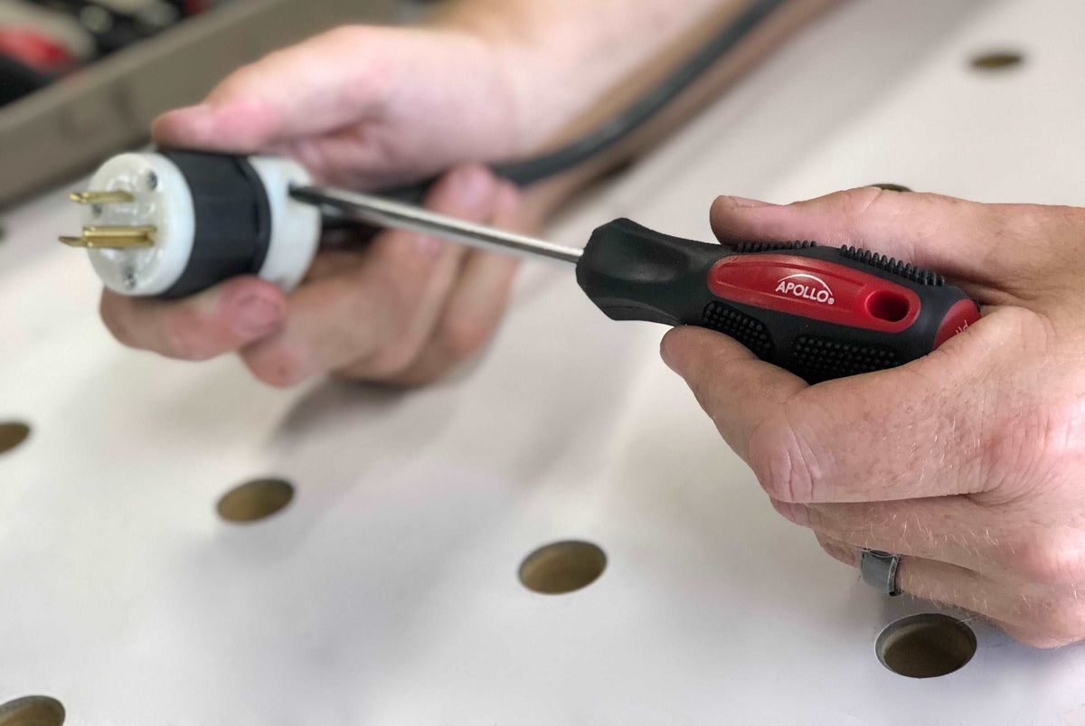 Hands using red and black Apollo screwdriver from Household Tool Kit to fix electrical plug