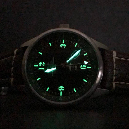 B-17 Tribute watch with stainless brush finish, dark green dial, and brown leather band with stitching