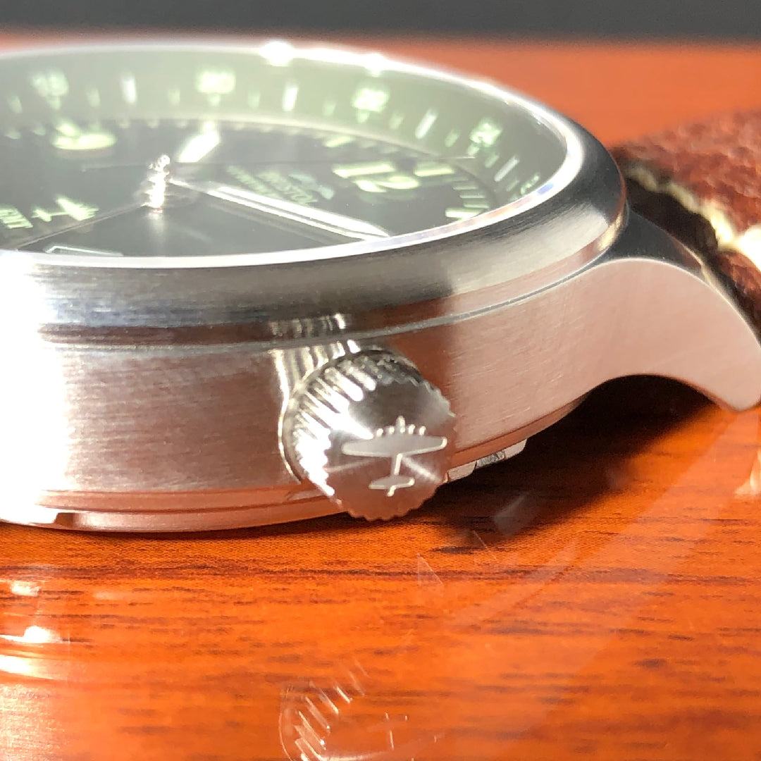 B-17 Tribute wristwatch with stainless brush finish, dark green dial, and brown leather band with stitching