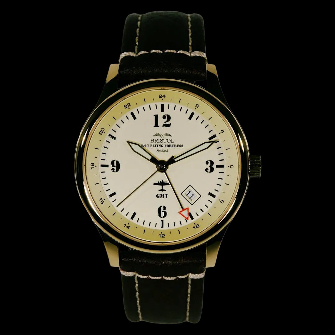 B-17 Tribute watch with gold finish, beige dial, stainless steel case, brown leather strap, and original B-17 Flying Fortress airframe artifact display