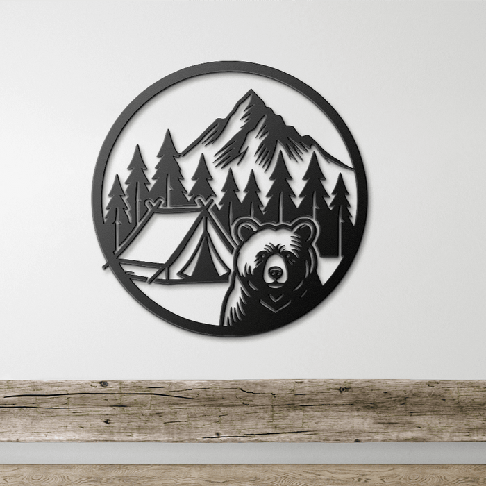 Black metal wall art depicting a bear, camping tent, trees, and mountain in a circular design