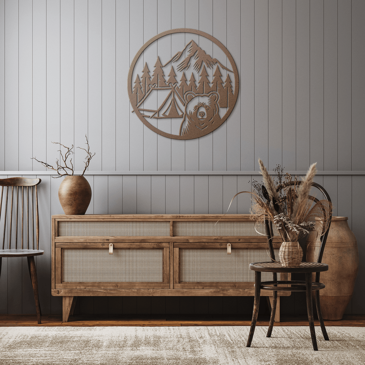 Rustic metal wall art featuring a bear camping scene with mountains and trees in a circular design above a wooden sideboard.