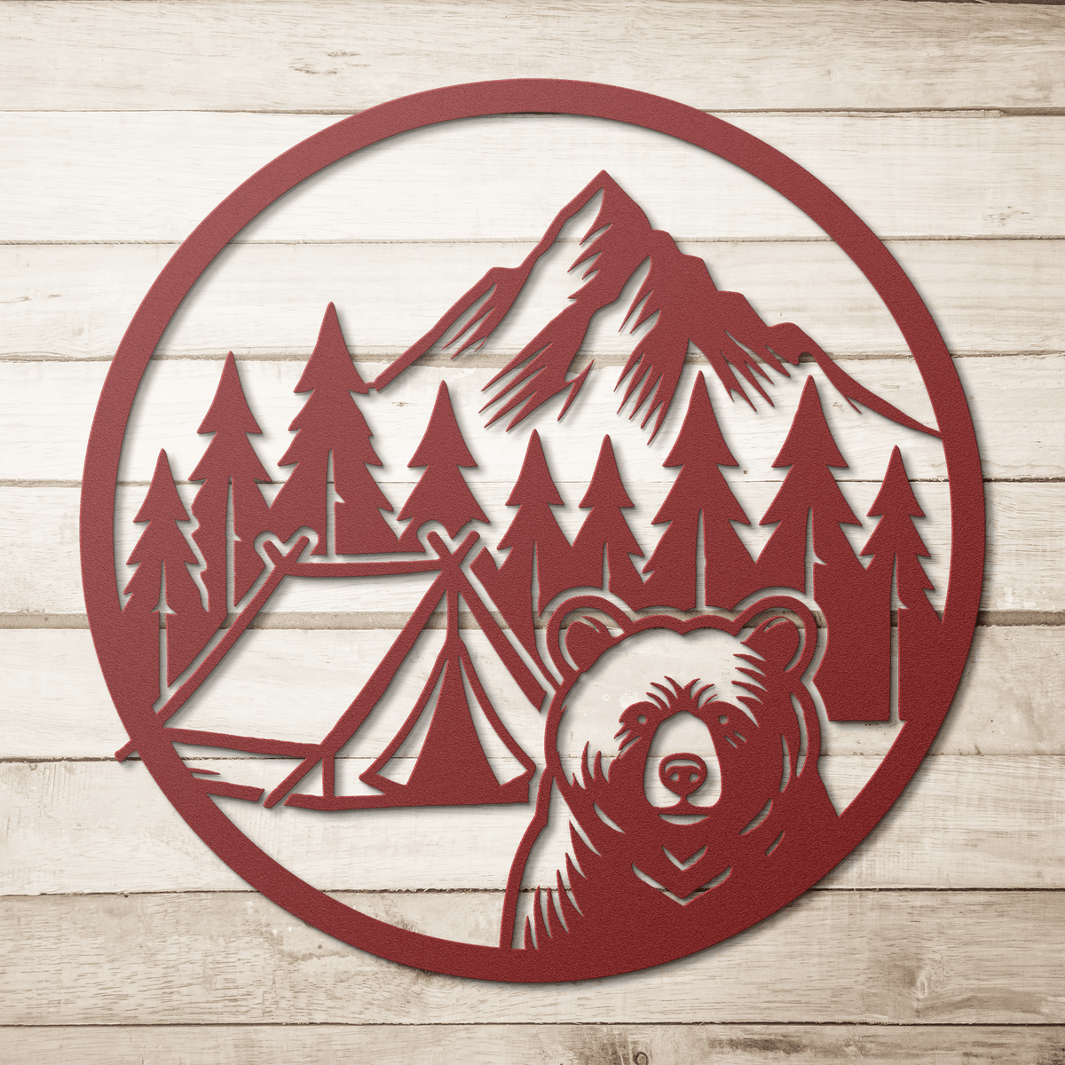 Red metal wall art featuring a bear, camping tents, pine trees, and mountains in a circular design.
