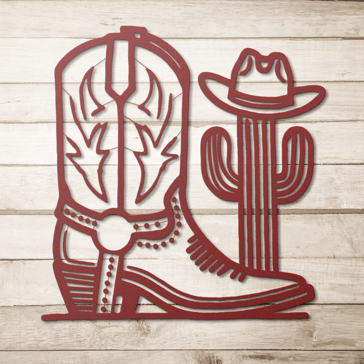 Red metal cowboy boot and cactus wall art sign on wooden background