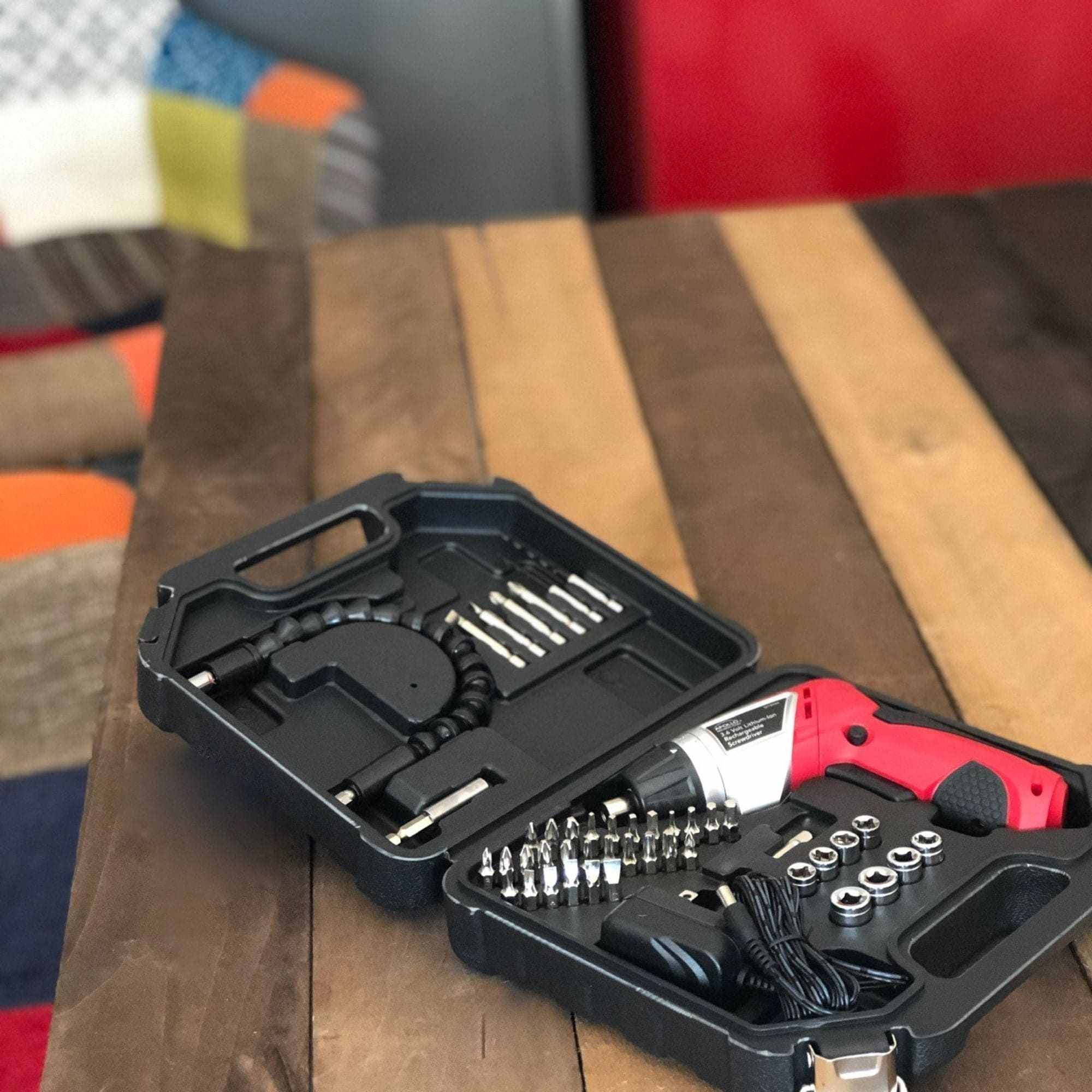 3.6 Volt Lithium-Ion Rechargeable Screwdriver kit with 45-piece accessory set in black carrying case on wooden table