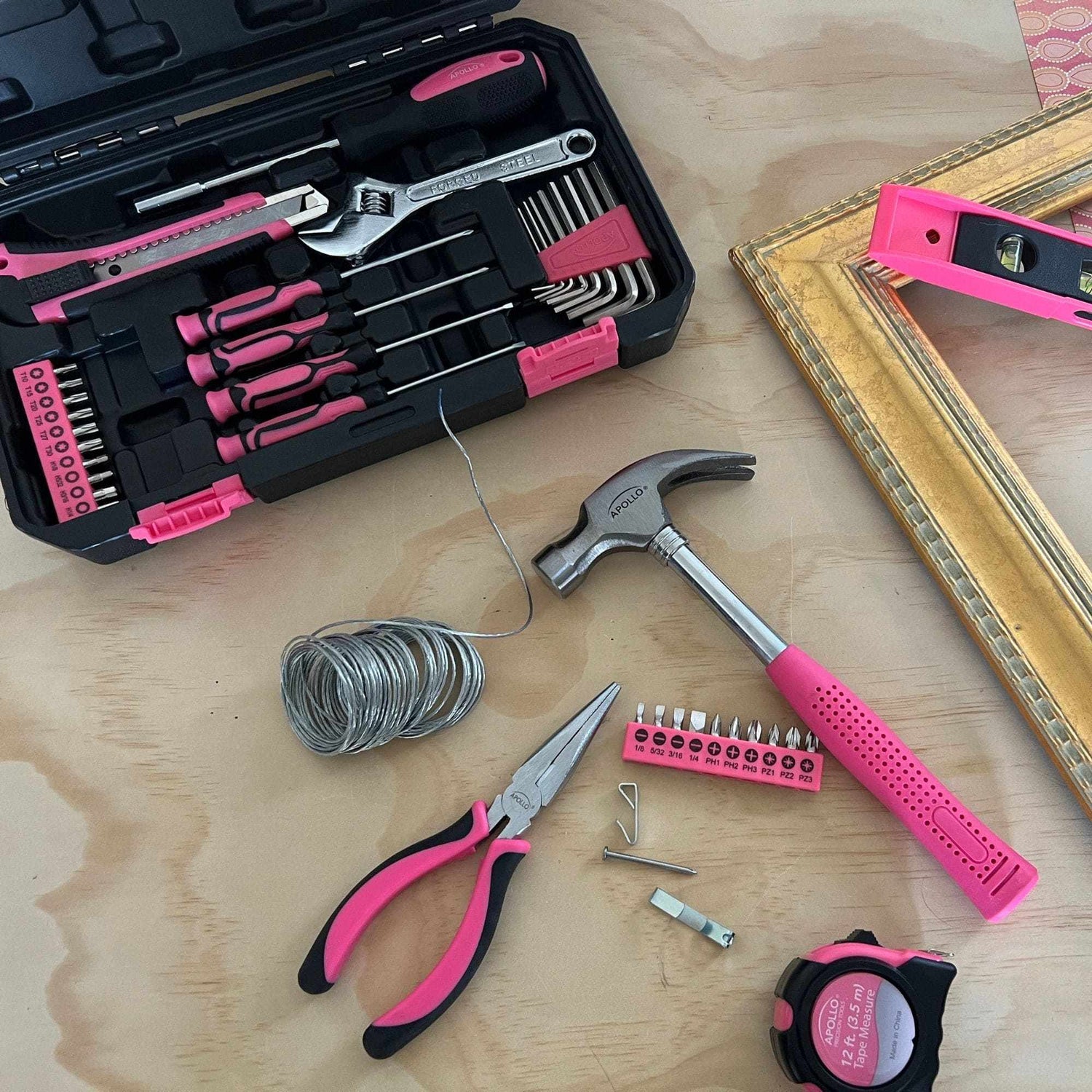 Pink tool set with hammer, pliers, screwdrivers, wrench, tape measure, and storage case for DIY home repairs