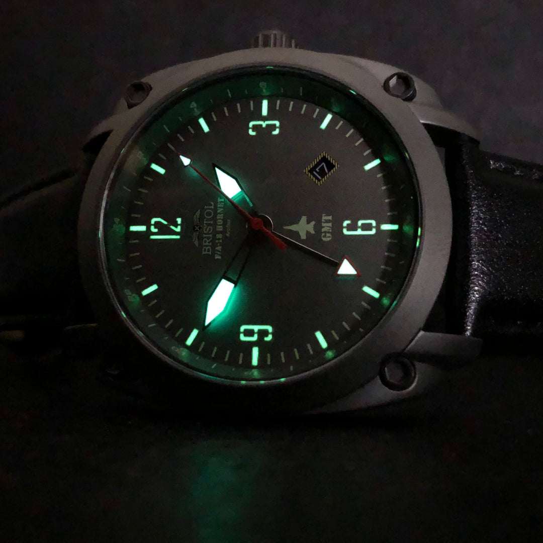 F-18 Hornet tribute watch with gunmetal finish, gray dial, glowing hands, and black leather strap
