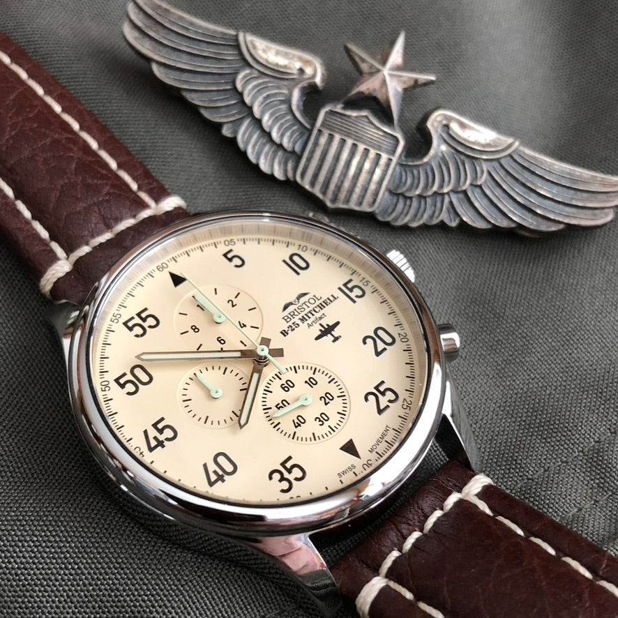 B-25 Mitchell tribute watch with polished stainless steel case, beige dial, and brown leather band with stitching