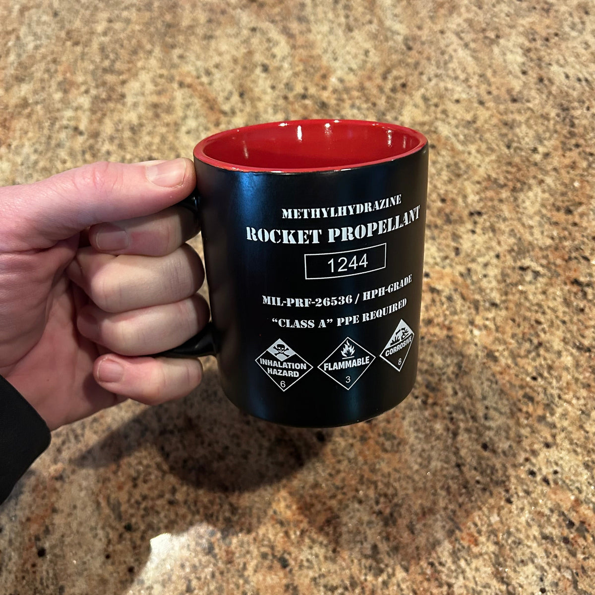 Rocket propellant coffee mug shaped like a NASA fuel drum with hazard markings and red interior