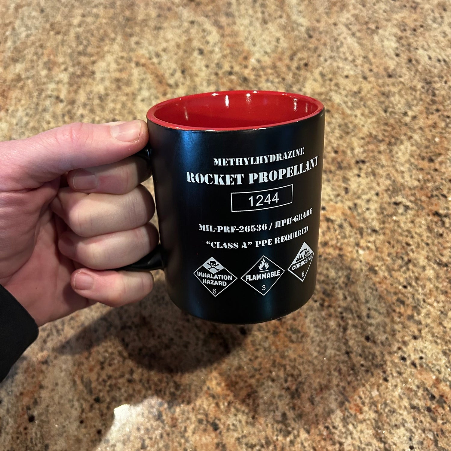 Rocket propellant coffee mug shaped like a NASA fuel drum with hazard markings and red interior