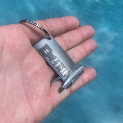 Hand holding a silver keychain with &