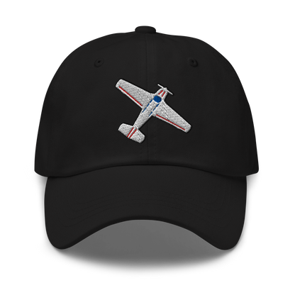 A black baseball cap featuring an embroidered silver, red, and blue vintage airplane on the front, set against a plain white background.