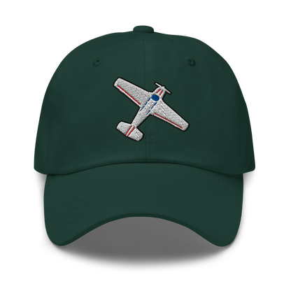 A dark green baseball cap featuring an embroidered airplane patch on the front, set against a plain white background with a soft drop shadow.