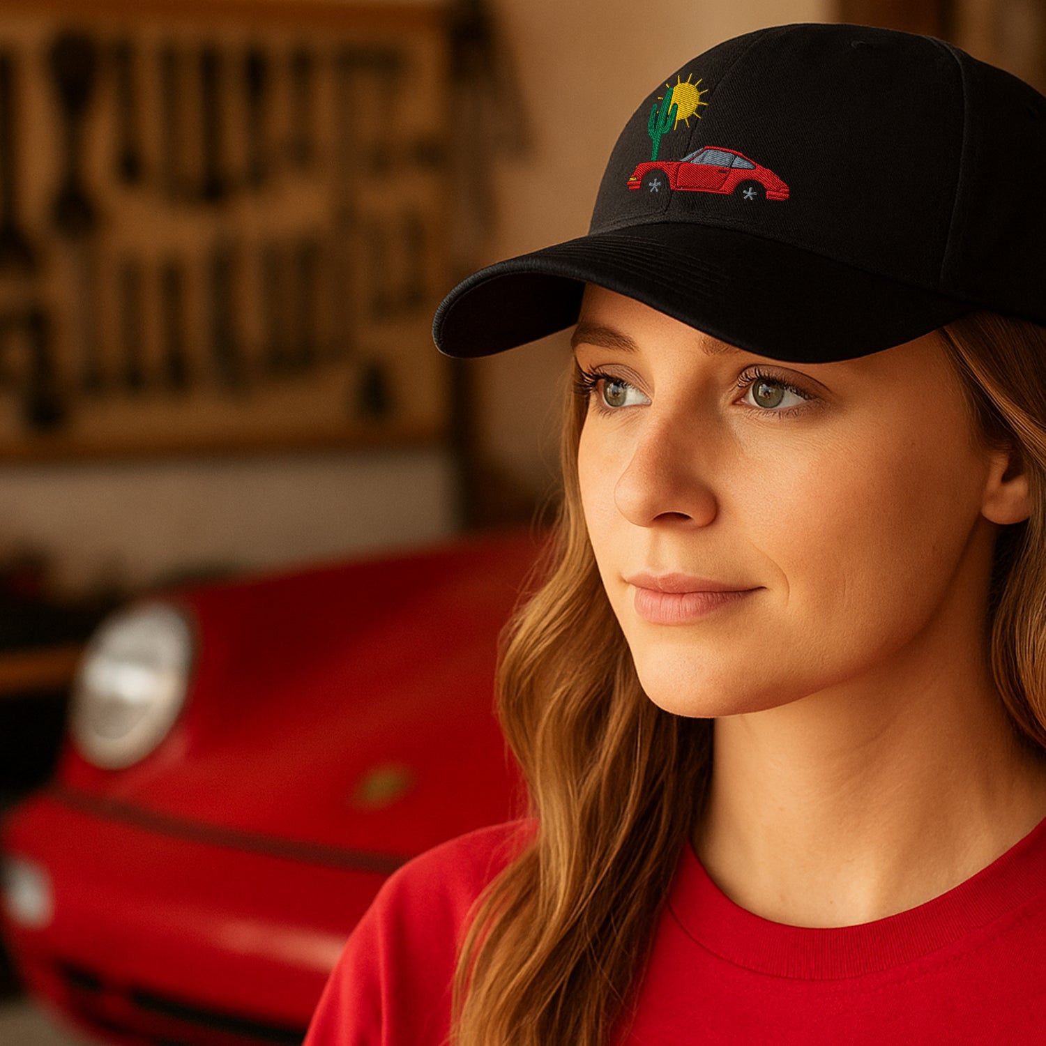 Automotive Hats and Aviation Hat Woman wearing a black cap with a car design, standing in front of a red car.