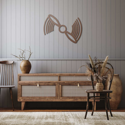 Copper propeller metal wall art mounted on a gray paneled wall above wooden furniture in a rustic living space