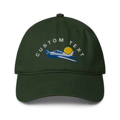 Green cap with airplane and sun design on a white background