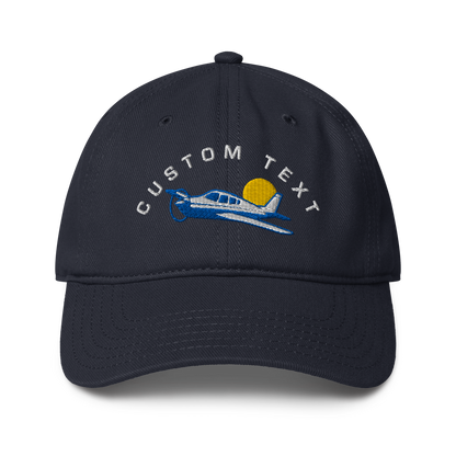 Navy blue cap with airplane and sun design on a white background