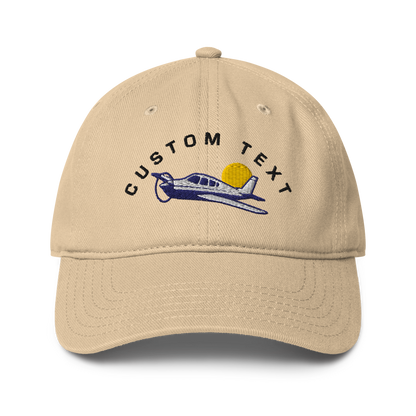 Beige cap with airplane and sun design on a white background