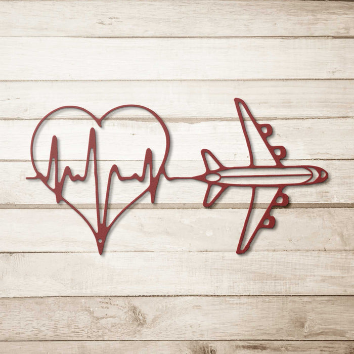 Minimalist metal wall art featuring heartbeat line forming a heart and airplane design in red for travel decor