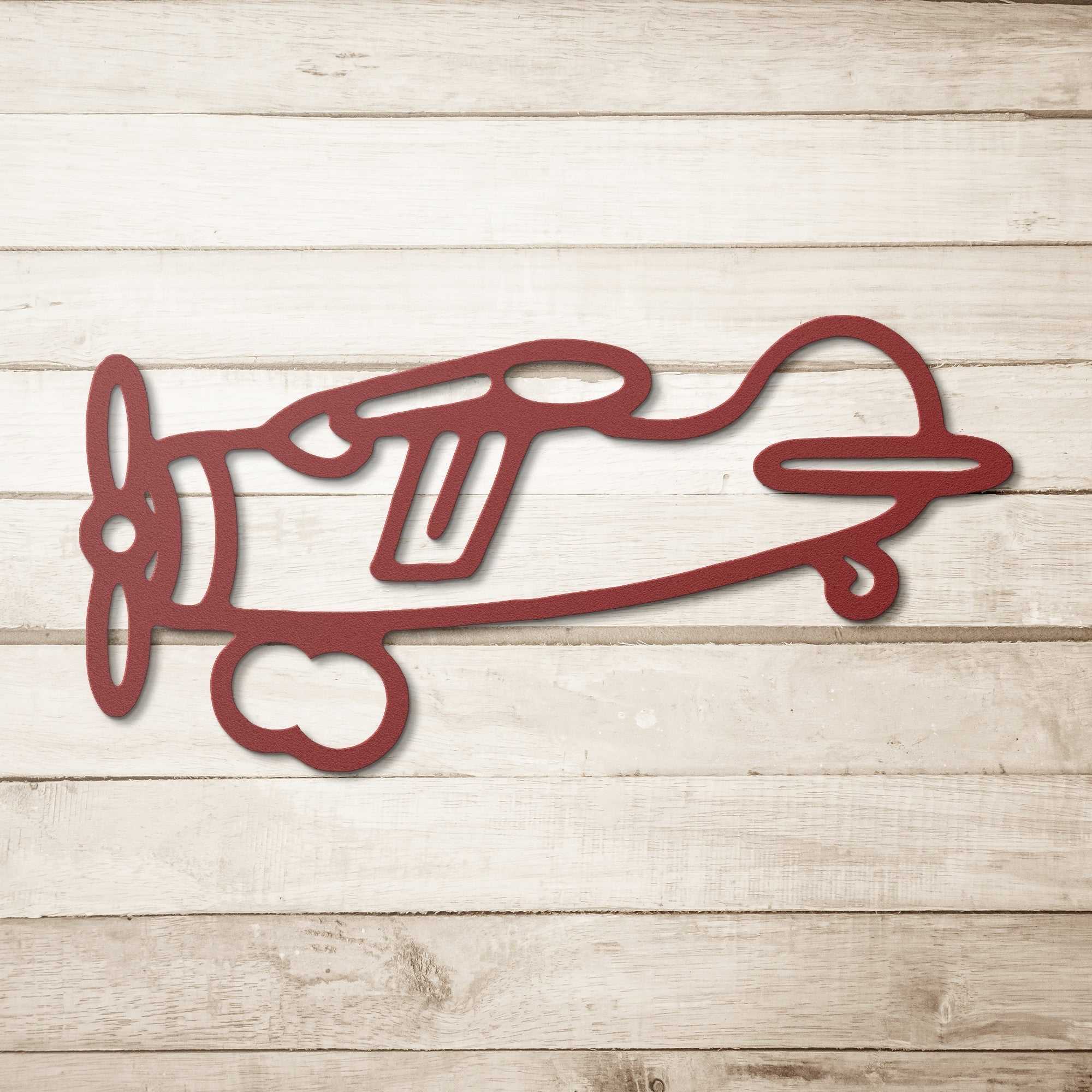 Vintage airplane metal wall art featuring a red airplane design on a wooden background, perfect for aviation decor.
