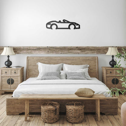 Automotive metal wall art convertible silhouette in black powder-coated steel above bedroom bed