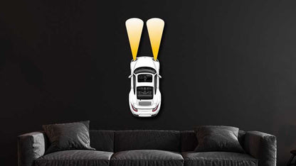 PCAR Headlights White metal wall art showing a white car with yellow headlights on a dark wall above a gray sofa in a modern living room