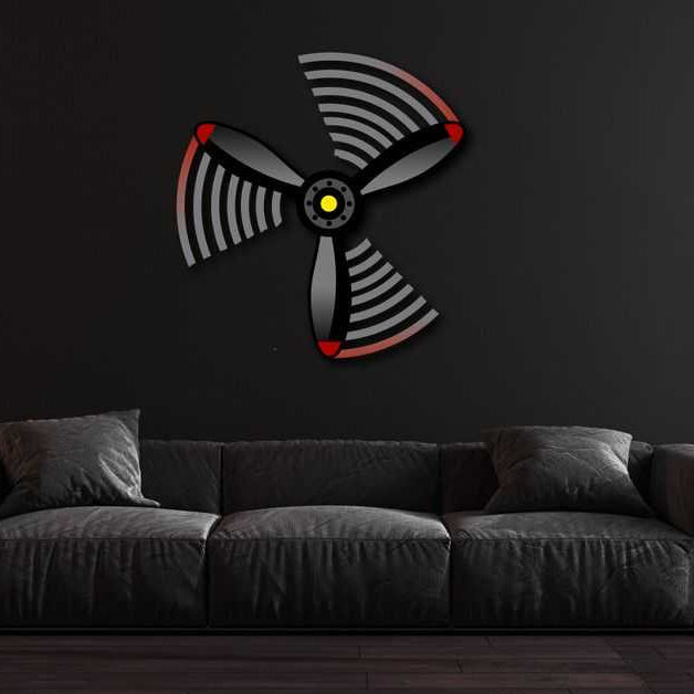 Multicolor metal sign wall art shaped like a propeller mounted on black wall above dark gray sofa